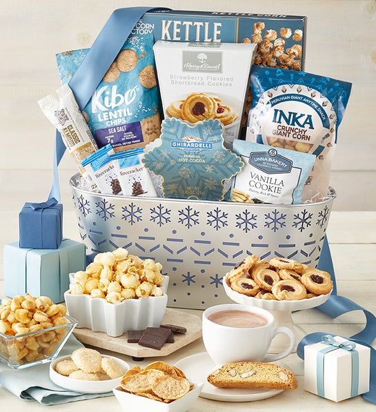 A silver gift basket filled with and surrounded by kosher snacks